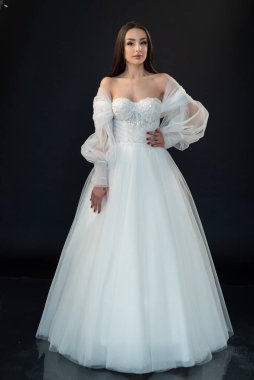  gelin siyah arka planda gelinlik pozu veriyor 