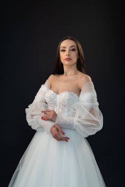  gelin siyah arka planda gelinlik pozu veriyor 