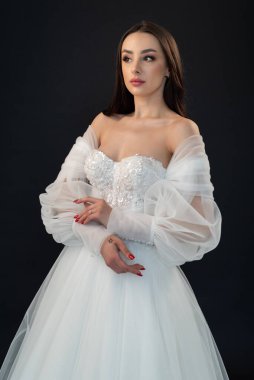  gelin siyah arka planda gelinlik pozu veriyor 