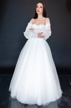  gelin siyah arka planda gelinlik pozu veriyor 