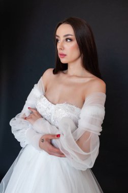  gelin siyah arka planda gelinlik pozu veriyor 