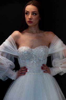  gelin siyah arka planda gelinlik pozu veriyor 