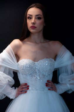  gelin siyah arka planda gelinlik pozu veriyor 