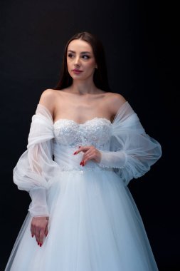  gelin siyah arka planda gelinlik pozu veriyor 