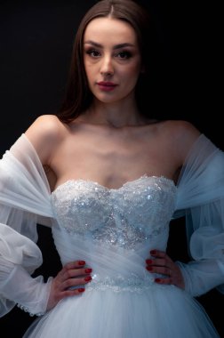  gelin siyah arka planda gelinlik pozu veriyor 