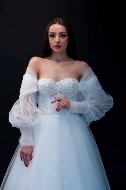  gelin siyah arka planda gelinlik pozu veriyor 