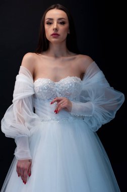  gelin siyah arka planda gelinlik pozu veriyor 