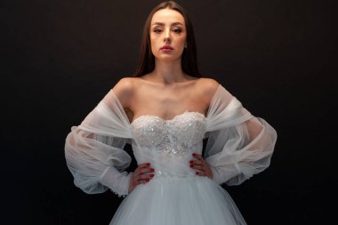  gelin siyah arka planda gelinlik pozu veriyor 