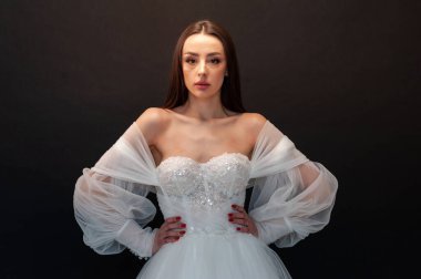  gelin siyah arka planda gelinlik pozu veriyor 