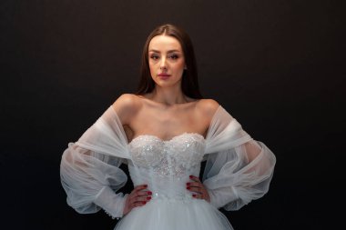  gelin siyah arka planda gelinlik pozu veriyor 