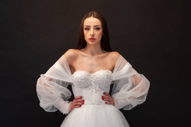  gelin siyah arka planda gelinlik pozu veriyor 