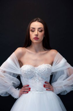  gelin siyah arka planda gelinlik pozu veriyor 