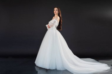 Siyah arka planda beyaz elbise içinde güzel bir gelin.