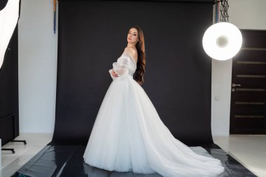 Stüdyoda poz veren beyaz elbiseli güzel gelin.