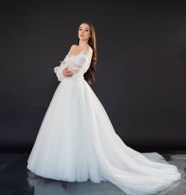 Siyah arka planda beyaz elbise içinde güzel bir gelin.