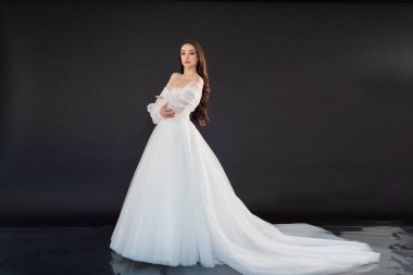 Siyah arka planda beyaz elbiseli güzel bir gelin.