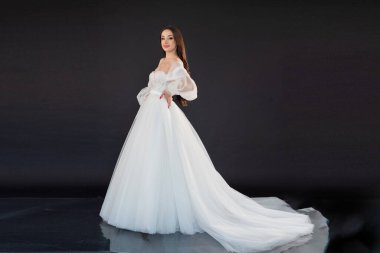 Siyah arka planda beyaz elbiseli güzel bir gelin.