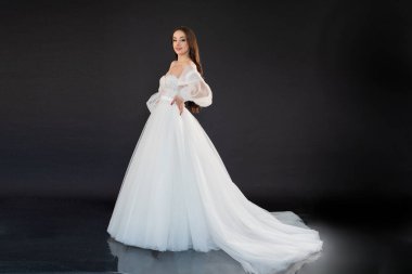 Siyah arka planda beyaz elbise içinde güzel bir gelin.