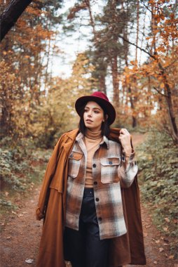 Güz parkında güzel esmer bir kadın. 