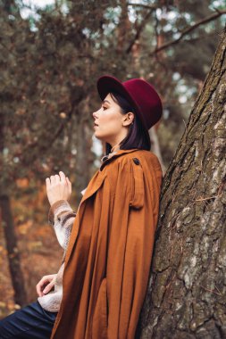 Sonbahar ormanında güzel, şık bir kız. 