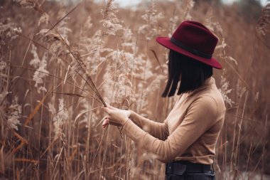 Sonbahar parkındaki şapkalı kız. 