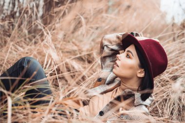 Güz parkında şapkalı güzel bir kadın. 