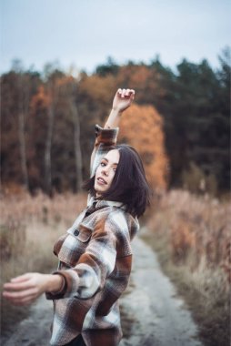 Sonbahar ormanında şapkalı genç bir kadın. 