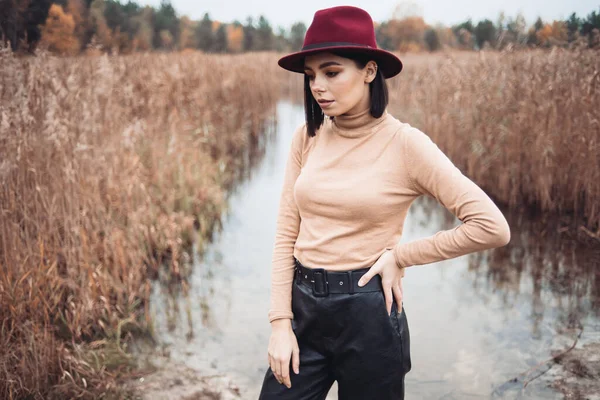 湖を背景に赤い帽子とセーターを着た少女が — ストック写真