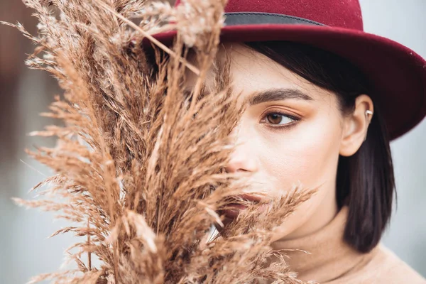 赤い帽子と秋の葉を持つスタイリッシュな女性の肖像 — ストック写真