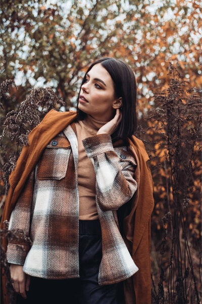 young beautiful brunette woman posing in the forest 