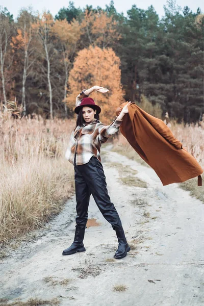 帽子の美しい女性と森の中を歩く黒い革のジャケット — ストック写真