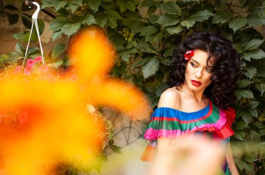 Çiçeklerin yanında poz veren kadın 