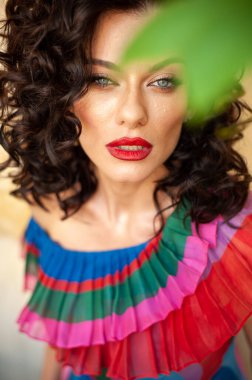 Güzel esmer, kırmızı dudaklı, yeşil gözlü, kırmızı elbiseli 