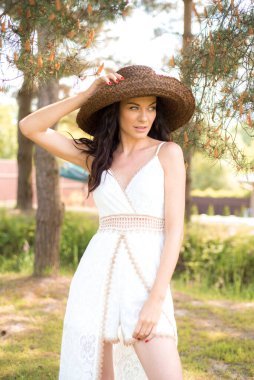 Yaz bahçesinde beyaz elbise giyen güzel esmer kadının portresi. 