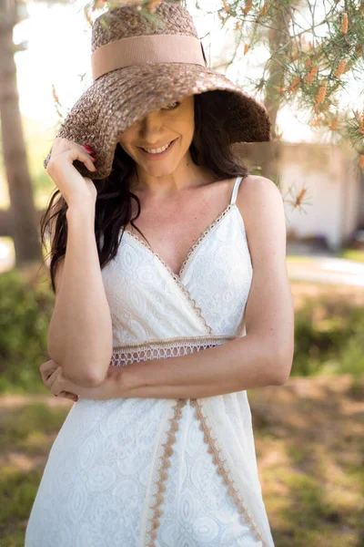 晴れた日に公園でポーズをとっている白いドレスを着た美しい若い女性 — ストック写真