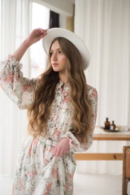 Beyaz elbiseli ve şapkalı güzel kız. 