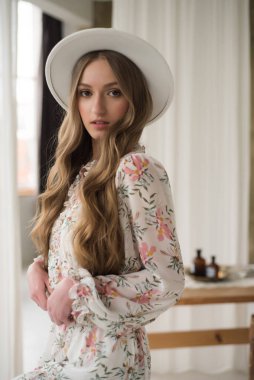 Beyaz elbiseli ve şapkalı güzel sarışın. 