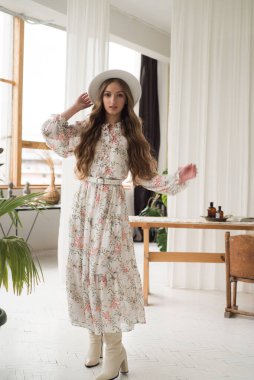 Uzun beyaz bir bluz ve şapka giyen güzel bir kız. 