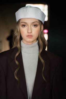 Şık şapkalı güzel bir genç kız bir odada duruyor.. 