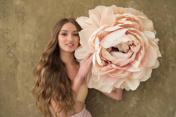 красивая молодая женщина с длинными волосами, держащая букет пионов 