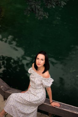 Yaz parkında beyaz elbiseli güzel bir kız. Bir kızın portresi.