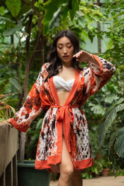 Genç, güzel Asyalı kadın parkta poz veriyor.