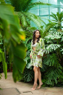 Portre güzel Asyalı kadın rahatla ve tatil için tropikal bahçe otelinde gülümse.