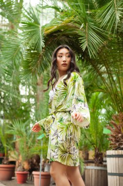 Tropik bir bahçede genç Asyalı bir kızın portresi