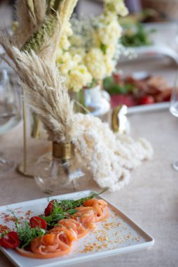 Düğünde ya da akşam yemeğinde ahşap masada çiçekler ve çatal bıçaklarla güzel bir masa.