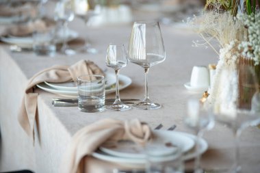 Düğünde ya da akşam yemeğinde ahşap masada çiçekler ve çatal bıçaklarla güzel bir masa.