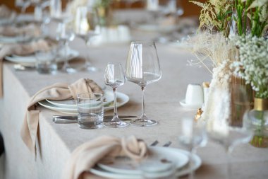 Düğünde ya da akşam yemeğinde ahşap masada çiçekler ve çatal bıçaklarla güzel bir masa.