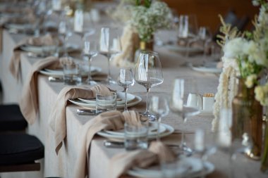 Düğünde ya da akşam yemeğinde ahşap masada çiçekler ve çatal bıçaklarla güzel bir masa.