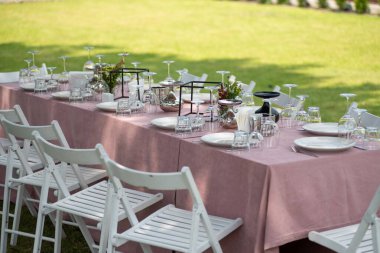 Pembe çiçekli ve mumlu konuklar için bir masa.