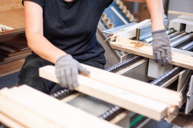 Fabrikada ahşap kalasla çalışan kadın işçi.